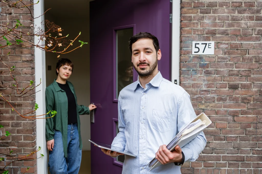 Professional met map en documenten bij huisdeur 57E, verwelkomd door bewoner, leren werken in het sociaal domein