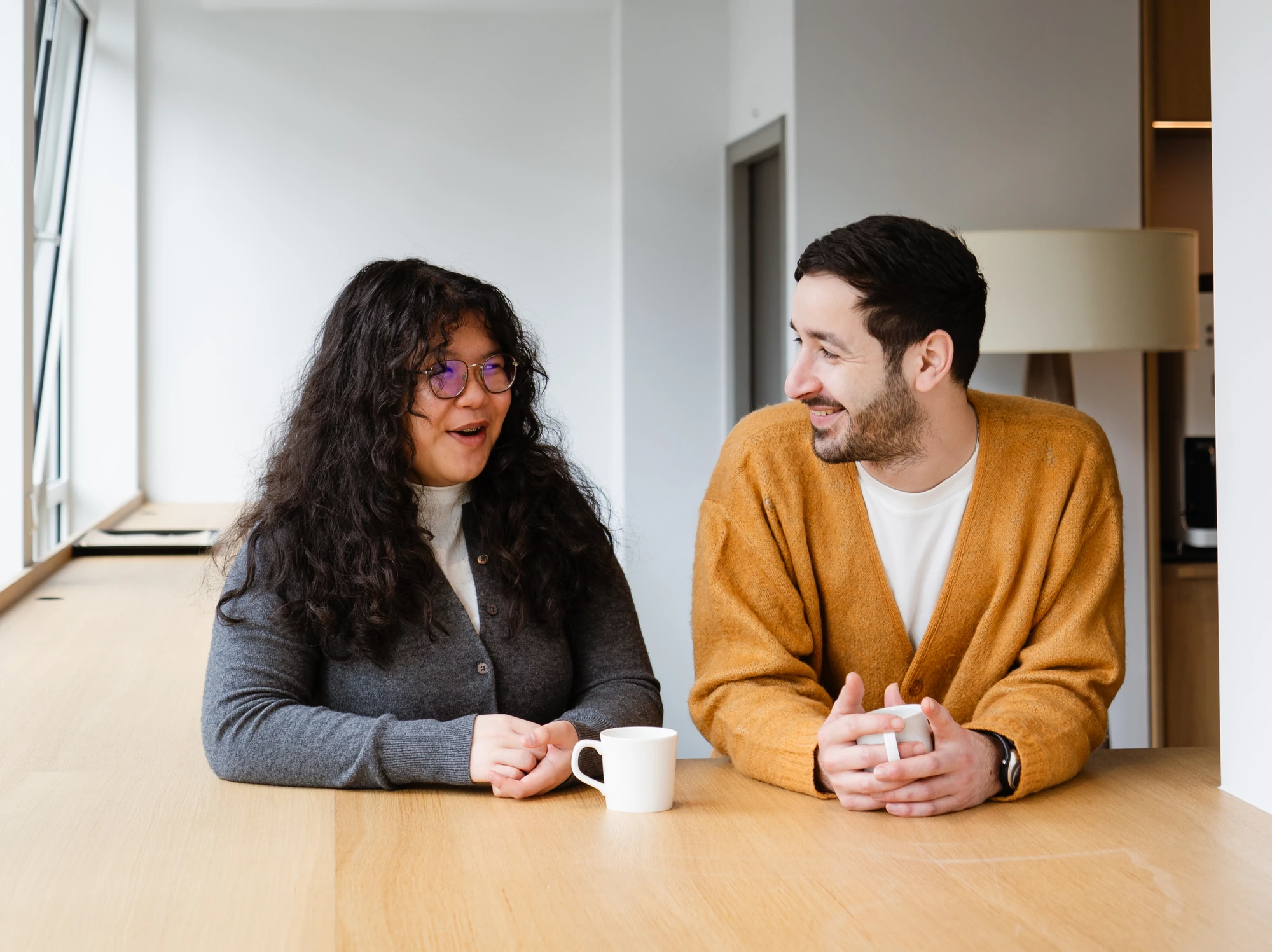 Twee professionals in gesprek aan een tafel met koffie tijdens een opleiding bij PEX Academy sociaal domein