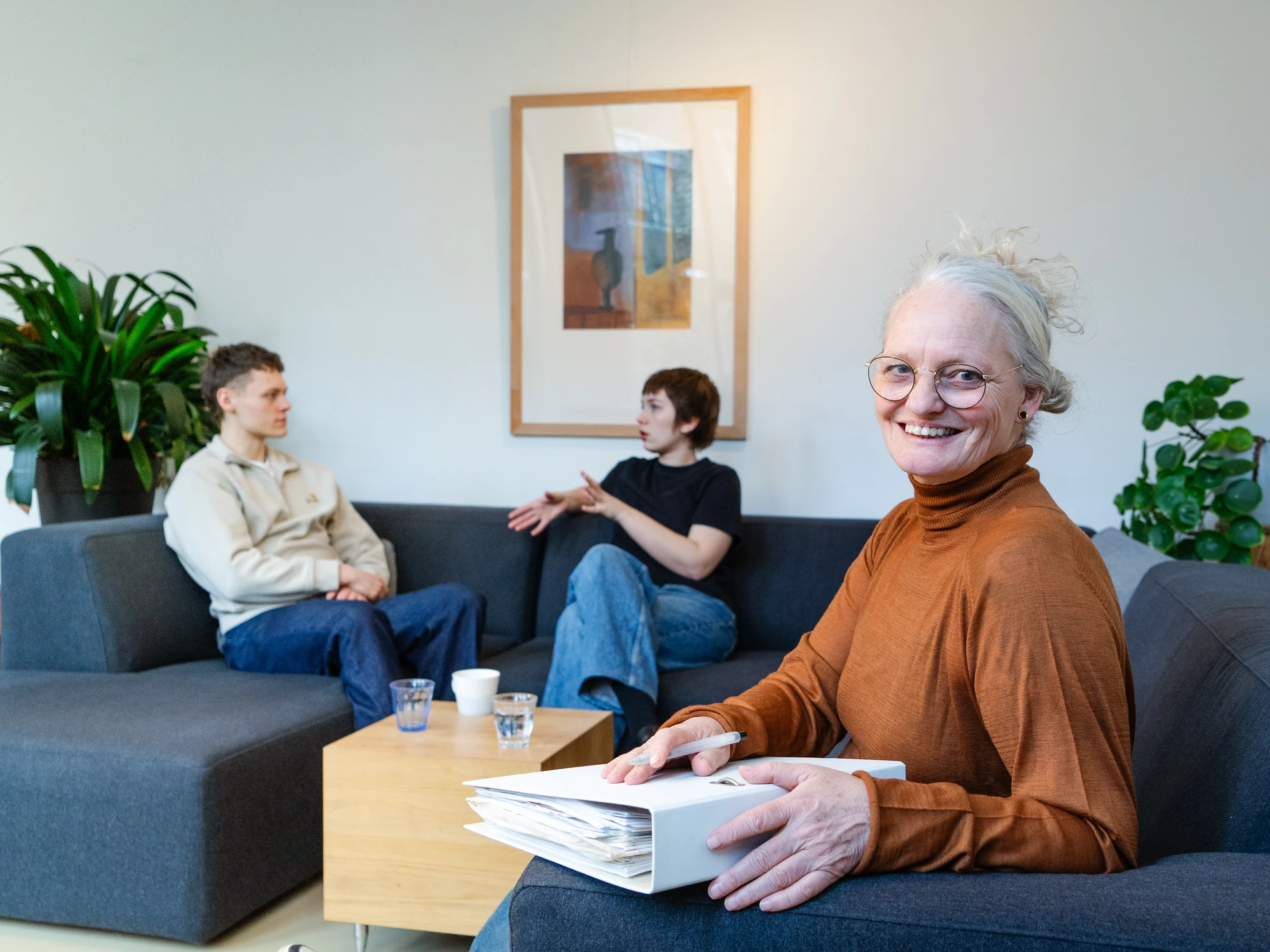 Ervaren trainer van PEX Academy begeleidt twee jonge professionals in het sociaal domein tijdens een opleidingssessie